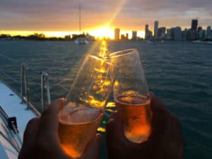 couple celebrating creating their luxury crewed charter business with champagne after working with catamaran guru