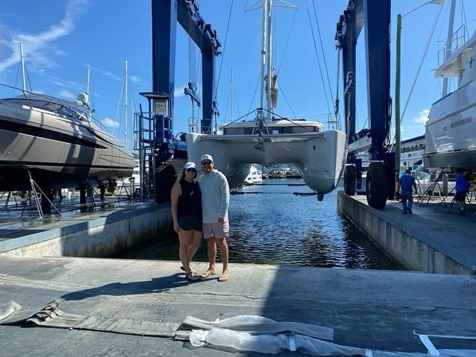 the burkes standing in front of their hauled-out 2018 lagoon 450f | The Catamaran Gurus the burkes standing in front of their hauled-out 2018 lagoon 450f