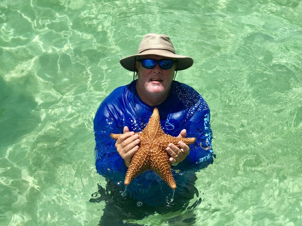 stephen cockcroft in the bahamas holding a very large starfish